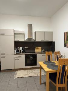 a kitchen with white cabinets and a table and a stove at Ferienwohnung Louis in Gerolstein