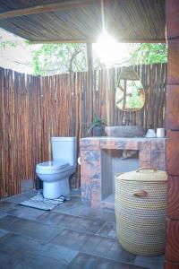 a bathroom with a toilet and a stone fireplace at De Dek Venue & Accommodation in Guthrie +23 photos