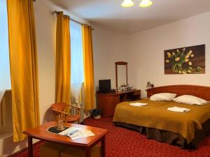a hotel room with a bed and a table at Hotel Przy Oślej Bramie - Zamek Książ in Wałbrzych
