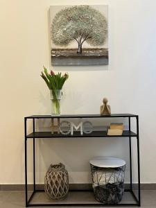 a black shelf with a vase and a tree on the wall at Ferienwohnung Louis in Gerolstein