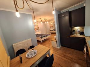 a kitchen and dining room with a table and a room with a bed at U Rudobrodego in Pogórze