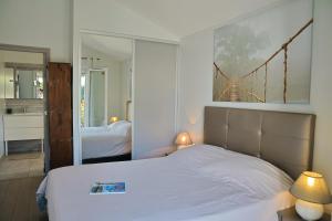 a bedroom with a white bed and a large mirror at MAISON GANTTIPIENEA in Ahetze