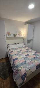 a bedroom with a bed with a quilt on it at Moradia Belo horizonte in Alfena