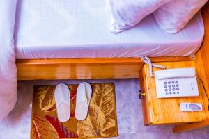 a pair of shoes and a phone on a bed at Grace villa in Zame +10 photos