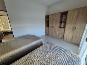 a bedroom with two beds and wooden cabinets at Turquesa depa in Cabo San Lucas