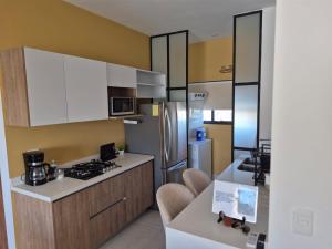 a kitchen with white cabinets and a refrigerator at Turquesa depa in Cabo San Lucas +13 photos