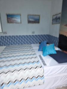 a bed with two blue pillows on top of it at Flat Lagoa Azul in Maragogi