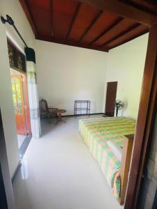 a bedroom with a bed and a table in it at Iwasuma Homestay in Dickwella