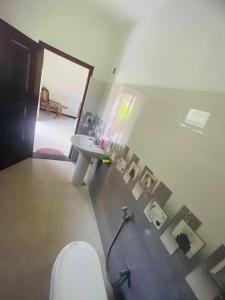 a bathroom with a toilet and a sink and a mirror at Iwasuma Homestay in Dickwella