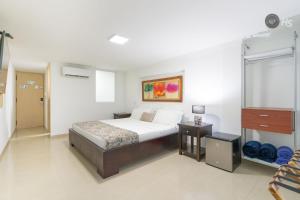 a bedroom with a bed and a dresser in it at Hotel Arhuaco Rodadero in Santa Marta