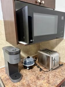 a kitchen counter with a microwave and a toaster at Cozy 1-Bed Basement Suite in Calgary