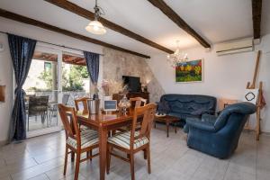 a living room with a table and chairs and a couch at South Estate in Čilipi