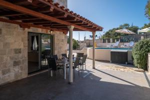 a patio with a table and chairs under a pergola at South Estate in Čilipi