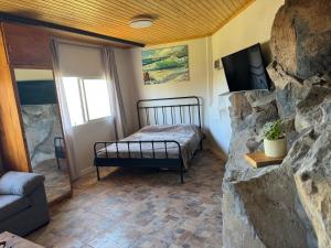 a bedroom with a bed and a stone wall at Casa Roca in Arona