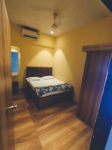 a bedroom with a bed and a wooden floor at Villa 04 in Mumbai