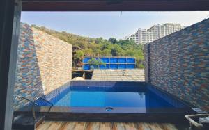 an empty swimming pool in a brick building at Villa 04 in Mumbai
