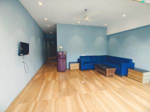 a living room with a blue couch and a tv at Villa 04 in Mumbai