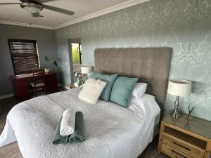 a bedroom with a large bed with towels on it at Chasing Jacuzzi Sunsets sea and mountain views in Hermanus