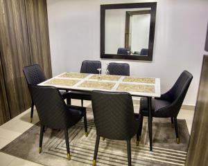 a dining room table with chairs and a mirror at Golden Tulip Hotel in Asaba