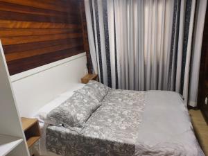 a small bedroom with a bed and a window at Chalé Vale Carahá Hortensia in Gramado