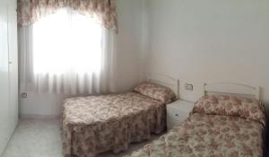 トレビエハにあるBelen Monteagudo 18の小さなベッドルーム(ベッド2台、窓付)