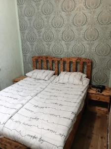 a bedroom with a bed with white sheets on it at Villa Gast Haus in Tsaghkadzor +9 photos