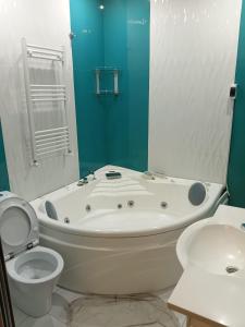 a bathroom with a tub and a toilet and a sink at Villa Gast Haus in Tsaghkadzor