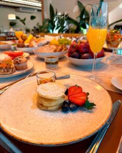 a table topped with a plate of food with fruit at Hotel Flat Afonso Pena in Campo Grande