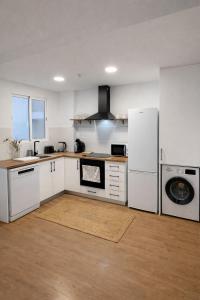 a kitchen with white cabinets and a white refrigerator at Apartaments Montseny in Girona