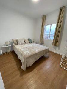 a white bedroom with a large bed and a window at Apartaments Montseny in Girona