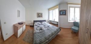 a bedroom with a bed and a blue chair at Hotel Haus Irsfeld in Waxweiler