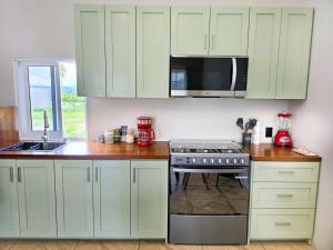 a kitchen with white cabinets and a stove top oven at Blue House near Tolantongo Caves in San Miguel