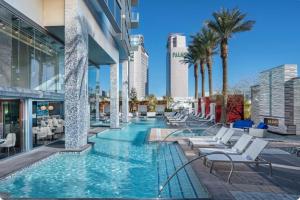 a pool at a hotel with chairs and palm trees at Palms Place in Las Vegas