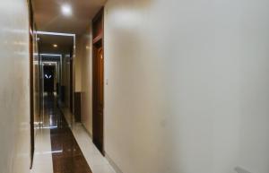 a hallway with a white wall next to a door at Hotel O Span Executive in Pune