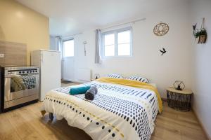 a bedroom with a bed and a refrigerator at Studio cosy - Jacuzzi inclus - À 5 min du Mans in Mulsanne