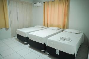 ein Zimmer mit zwei Betten in einem Zimmer in der Unterkunft Hotel Visconde in Sobral