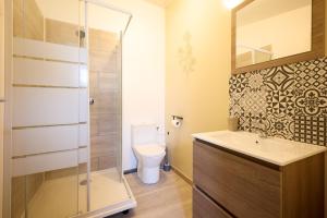 a bathroom with a toilet and a glass shower at Studio cosy - Jacuzzi inclus - À 5 min du Mans in Mulsanne