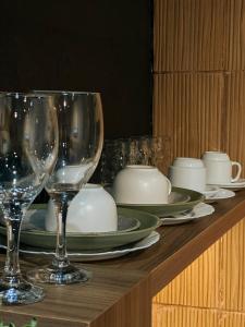 a table with wine glasses and plates on it at Espaços Cardoso, GRÊS - refúgio sólido e silencioso in Igrejinha