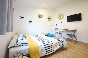 a bedroom with a bed and a desk and a television at Studio cosy - Jacuzzi inclus - À 5 min du Mans in Mulsanne +21 photos