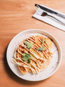 a bowl of pasta with greens on a table at Calle Flora Hotel by Jalo in Medellín +88 photos