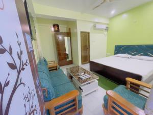 a bedroom with a bed and two chairs in it at The Cruze - Premium Hotel in Gulzārbāgh +13 photos