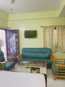 a living room with a couch and a tv at The Cruze - Premium Hotel in Gulzārbāgh