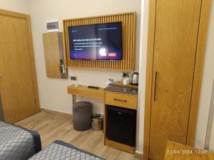 a room with a tv on a wall with a desk at Sultanahmet Newport Hotel in Istanbul +7 photos
