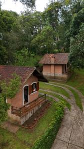 a small building with red apples in the grass at Chalés Lua de Mel in Monte Verde