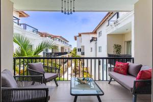 a balcony with a couch and chairs and a table at Novus Mare, Cabarete center! in Cabarete
