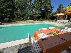 a table and chairs next to a swimming pool at Appartamento relax 5-4-3 in Rivalta Bormida