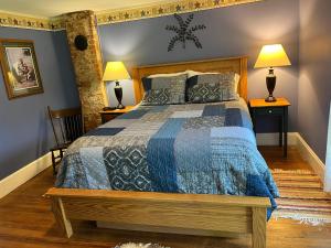 a bedroom with a bed with a blue comforter at Rainbow Ridge Farms in Onalaska +33 photos