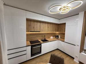 a kitchen with white cabinets and a chandelier at Luxury Residence in Baia Mare