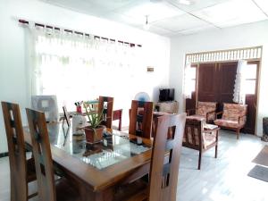 a dining room with a glass table and chairs at Vinal Inn Midigama in Midigama East