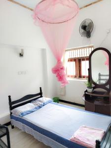 a bedroom with a bed and a mirror at Vinal Inn Midigama in Midigama East